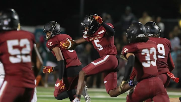 Oaks Christian's Davon Benjamin leaps through an opening after making an interception of a St. Bonaventure pass during the third quarter of the Marmonte League title game on Friday, Oct. 27, 2023, at Oak Christian's Thorson Stadium. Oaks Christian won 13-10.