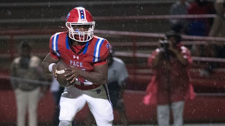 Pace quarterback Ben Tyner (No. 11) runs out of the pocket while looking for an open receiver during Friday night's game against Madison County. Pace quarterback Ben Tyner (No. 11) runs out of the pocket while looking for an open receiver during Friday night's game against Madison County.