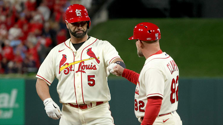 Pujols fist-bumps first base coach Stubby Clapp after reaching safely