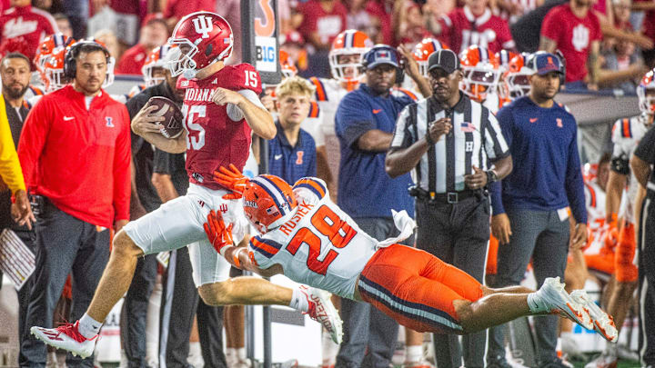 Indiana's Fernando Mendoza (15) is pushed by Illinois' Dylan Rosiek (28) as he runs during the Indiana versus Illinois football game at Memorial Stadium on Saturday, Sept. 20, 2025