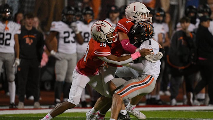 Ryan Petras #1 of the Bethel Park Black Hawks is wrapped up for a tackle by Jared Moyer #18 and Nicolas Prozzoly #1 of the Moon Tigers in the first half during the game at Tiger Stadium on Friday Night in Moon Township, Pennsylvania. Ryan Petras #1 of the Bethel Park Black Hawks is wrapped up for a tackle by Jared Moyer #18 and Nicolas Prozzoly #1 of the Moon Tigers in the first half during the game at Tiger Stadium on Friday Night in Moon Township, Pennsylvania.