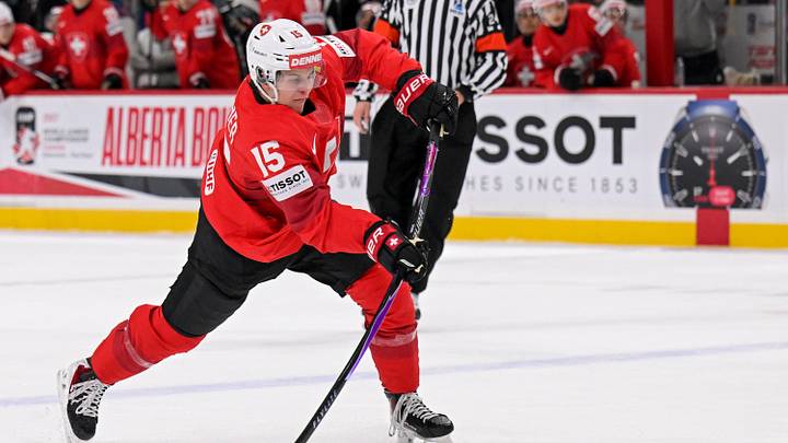 Switzerland forward Lars Steiner (15) shoots the puck during a IIHF World Junior Championship game between Switzerland and Slovakia
