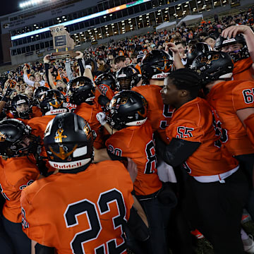 Platte County players hoist the championship trophy while celebrating their victory over Helias Catholic in Missouri Class 5 state title game.