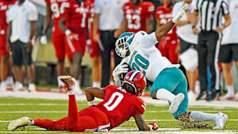 Coastal Carolina's Christian Washington tries to evade the tackle of Jacksonville State's Tyler Bride. 