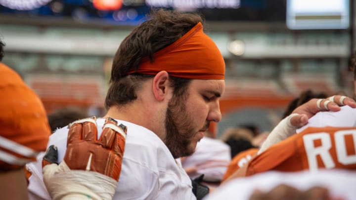 Texas White team offensive lineman Jake Majors (65) prays with the team following the Longhorns' spring Orange and White game at Darrell K Royal Texas Memorial Stadium in Austin, Texas, April 20, 2024.