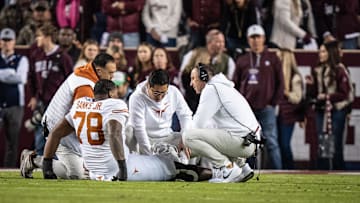 Nov 30, 2024; College Station, Texas, USA; Texas staff and Head Coach Steve Sarkisian attend to Texas Longhorns offensive lineman Kelvin Banks Jr. (78) after an injury in the first quarter of the Lone Star Showdown game against the Texas A&M Aggies at Kyle Field. Mandatory Credit: Sara Diggins/USA TODAY Network via Imagn Images