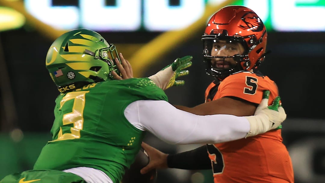 Oregon   s Brandon Dorlus, left, pressures Oregon State quarterback DJ Uiagalelei during the third