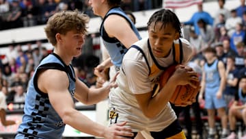 Garfield Heights' Marcus Johnson (right) covers up a rebound as Louisville's Ashton Marshall defends during an OHSAA Division III boys basketball state semifinal at Canton Memorial Field House on Sunday, March 16, 2025.