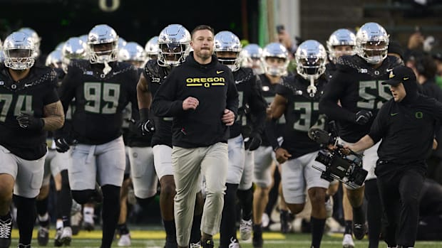 regon Ducks head coach Dan Lanning runs out with the team before a game against the Washington Huskies at Autzen Stadium.