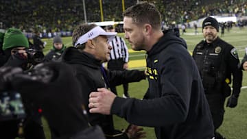 Nov 30, 2024; Eugene, Oregon, USA; Washington Huskies head coach Jedd Fisch, left, congratulates Oregon Ducks head coach Dan Lanning on his win after a game at Autzen Stadium. Mandatory Credit: Troy Wayrynen-Imagn Images