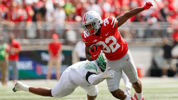 Running back makes defender miss on tackle.