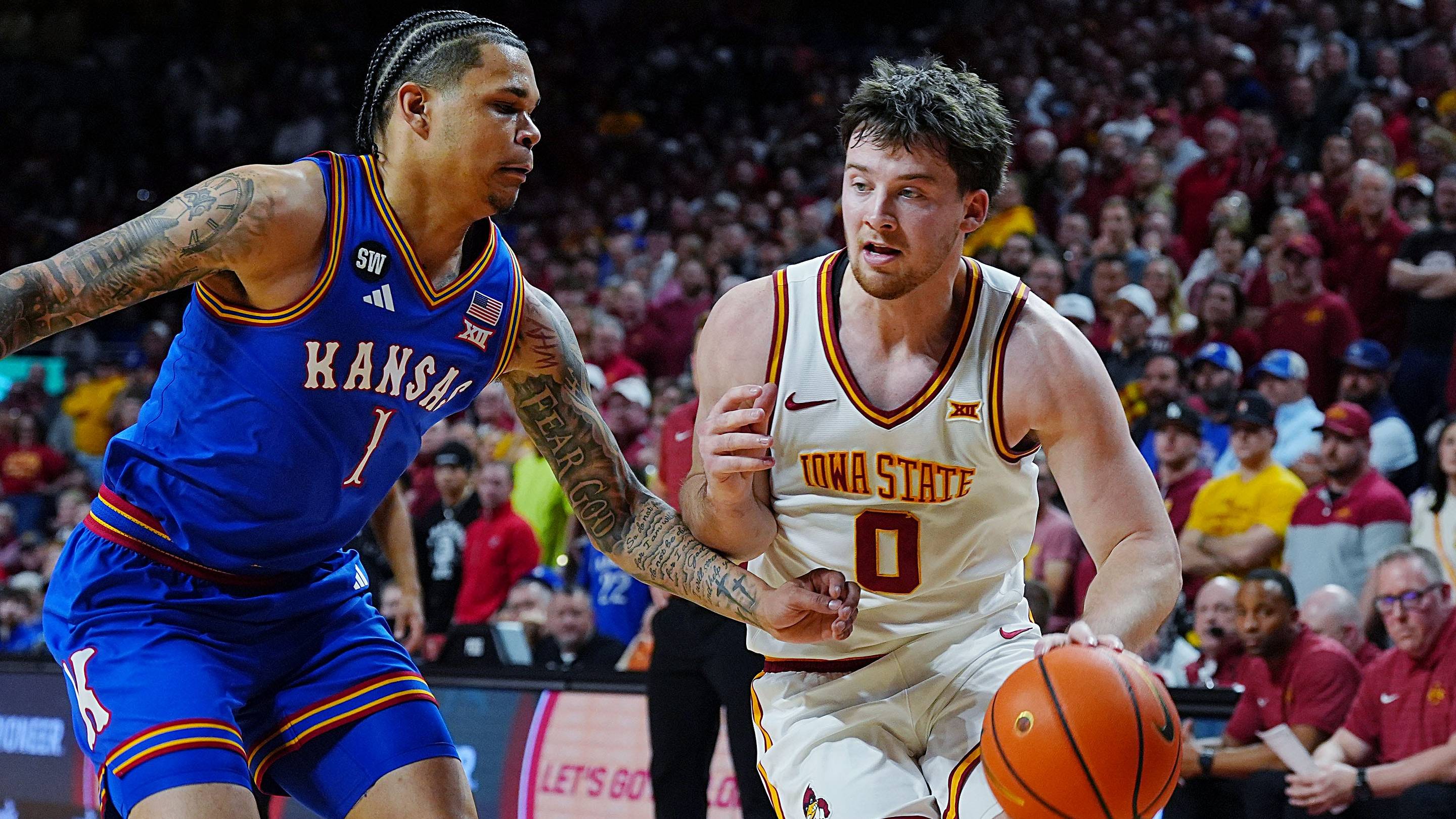 Iowa State Cyclones guard Nate Heise (0) drives with the ball around Kansas Jayhawks guard Jayden Dawson (1) during the second half in the Big-12 conference basketball showdown on Feb. 14, 2026, at Hilton Coliseum, in Ames, Iowa. | USA TODAY Network via Reuters Connect