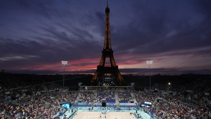 Jul 27, 2024; Paris, France; A general view of the Eiffel Tower as the sun sets before a beach volleyball preliminary phase match between Kristen Nuss and Taryn Kloth (USA) and Heather Bansley and Sophie Bukovec (CAN) during the Paris 2024 Olympic Summer Games at Eiffel Tower Stadium.