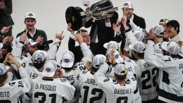 Michigan State hockey coach Adam Nightingale hoists the Big Ten tournament championship trophy after the Spartans beat Michigan 5-4 in overtime in Saturday night's title game at Munn Ice Arena in East Lansing.