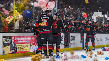 Coachella Valley Firebirds players celebrate a goal by forward Luke Henman triggering the teddy bear toss during the first period of their game at Acrisure Arena in Palm Desert, Calif., Saturday, Dec. 28, 2024.