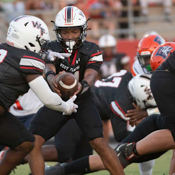 West Florida's Xavier Finley (No. 14) hands off to Zayvion Davis (No. 230 during Friday's 2024 football season home opener against Escambia.