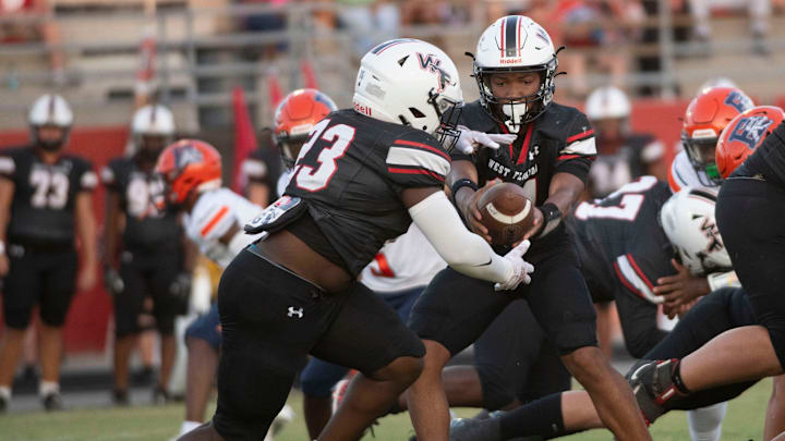 West Florida's Xavier Finley (No. 14) hands off to Zayvion Davis (No. 230 during Friday's 2024 football season home opener against Escambia.