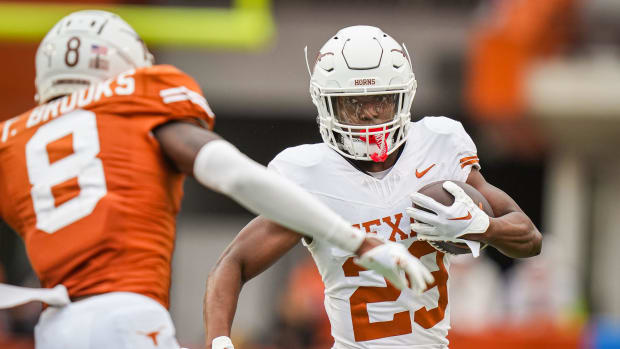 Texas White team running back Jaydon Blue (23) carry the ball while looking to evade defense from