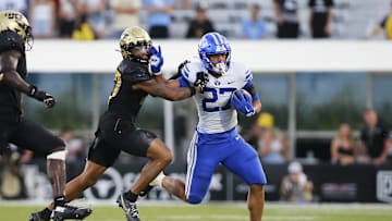 Oct 26, 2024; Orlando, Florida, USA;  Brigham Young Cougars running back LJ Martin (27) runs the ball against Central Florida Knights cornerback Chasen Johnson (27) in the second half at FBC Mortgage Stadium. Mandatory Credit: Russell Lansford-Imagn Images