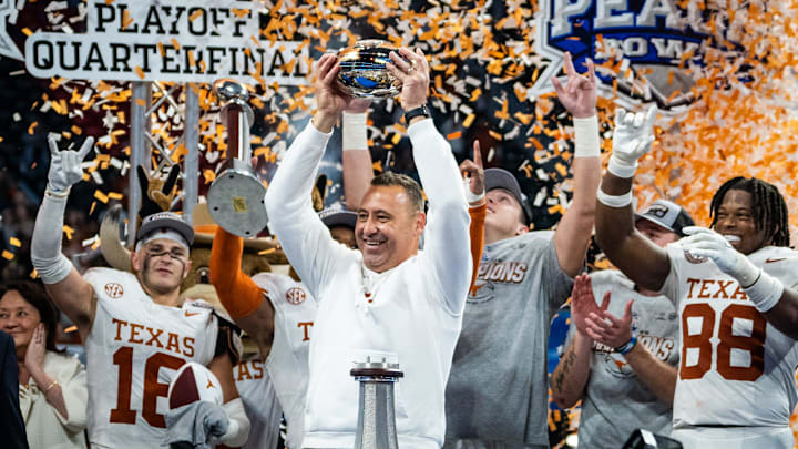 Texas Longhorns head coach Steve Sarkisian raises the trophy as the Texas Longhorns celebrate their 39-31 double overtime win over the Arizona State Sun Devils in the Peach Bowl College Football Playoff quarterfinal at Mercedes-Benz Stadium in Atlanta, Georgia, Jan. 1, 2025.