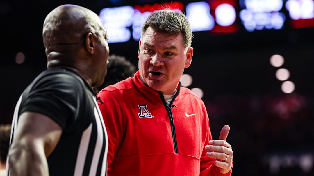 Jan 14, 2026; Tucson, Arizona, USA; Arizona Wildcats head coach Tommy Lloyd talks with the referee during the first half of the game against the Arizona State Sun Devils at McKale Memorial Center. Mandatory Credit: Aryanna Frank-Imagn Images