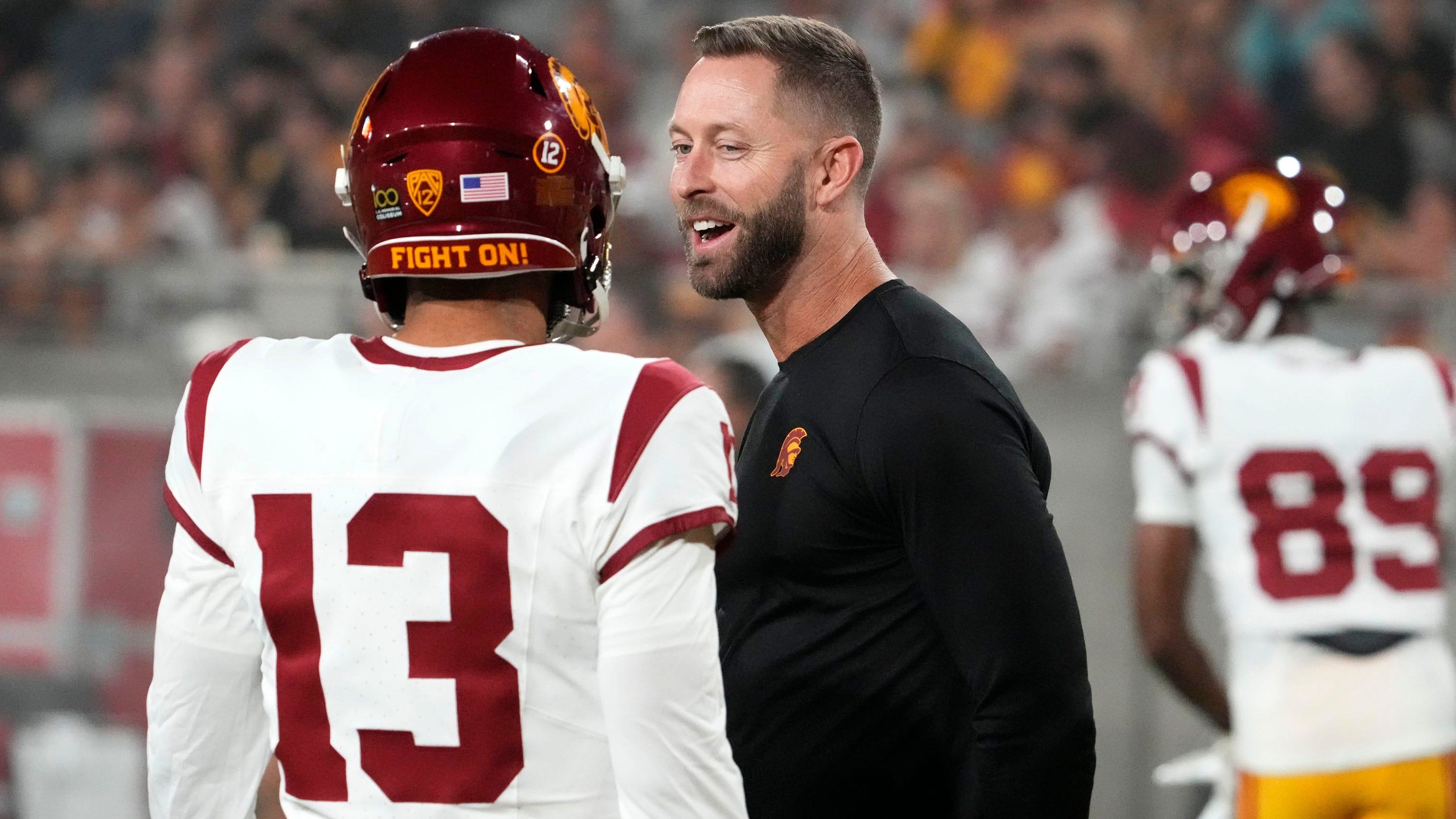 USC assistant coach Kliff Kingsbury talks to quarterback Caleb Williams on the sidelines.