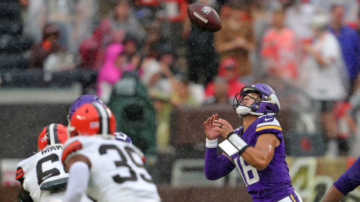 Minnesota Vikings quarterback Jaren Hall (16) lets the ball slip out of his hands in a steady rain during the second half of an NFL preseason football game at Cleveland Browns Stadium, Saturday, Aug. 17, 2024, in Cleveland, Ohio.