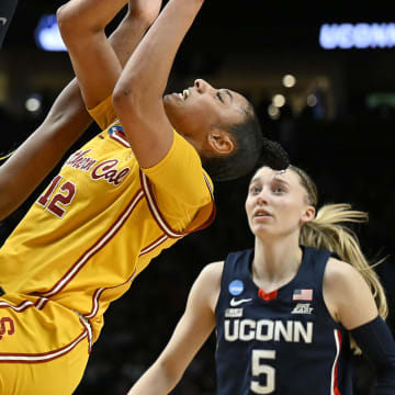 Apr 1, 2024; Portland, OR, USA; USC Trojans guard JuJu Watkins (12) puts up a shot during the second half against UConn Huskies forward Aaliyah Edwards (3) and guard Paige Bueckers (5) in the finals of the Portland Regional of the NCAA Tournament at the Moda Center. Mandatory Credit: Troy Wayrynen-USA TODAY Sports