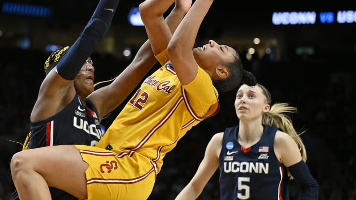 Apr 1, 2024; Portland, OR, USA; USC Trojans guard JuJu Watkins (12) puts up a shot during the second half against UConn Huskies forward Aaliyah Edwards (3) and guard Paige Bueckers (5) in the finals of the Portland Regional of the NCAA Tournament at the Moda Center. Mandatory Credit: Troy Wayrynen-USA TODAY Sports