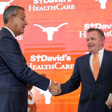 University of Texas baseball coach Jim Schlossnagle, right, is introduced by Athletic Director Chris Del Conte at his introductory news conference at the Frank Denius Family University Hall of Fame Wednesday June 26, 2024.