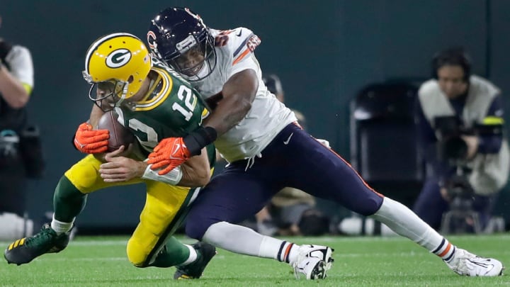 Chicago Bears defensive end Al-Quadin Muhammad (55) tackles scrambling Green Bay Packers quarterback Aaron Rodgers (12).