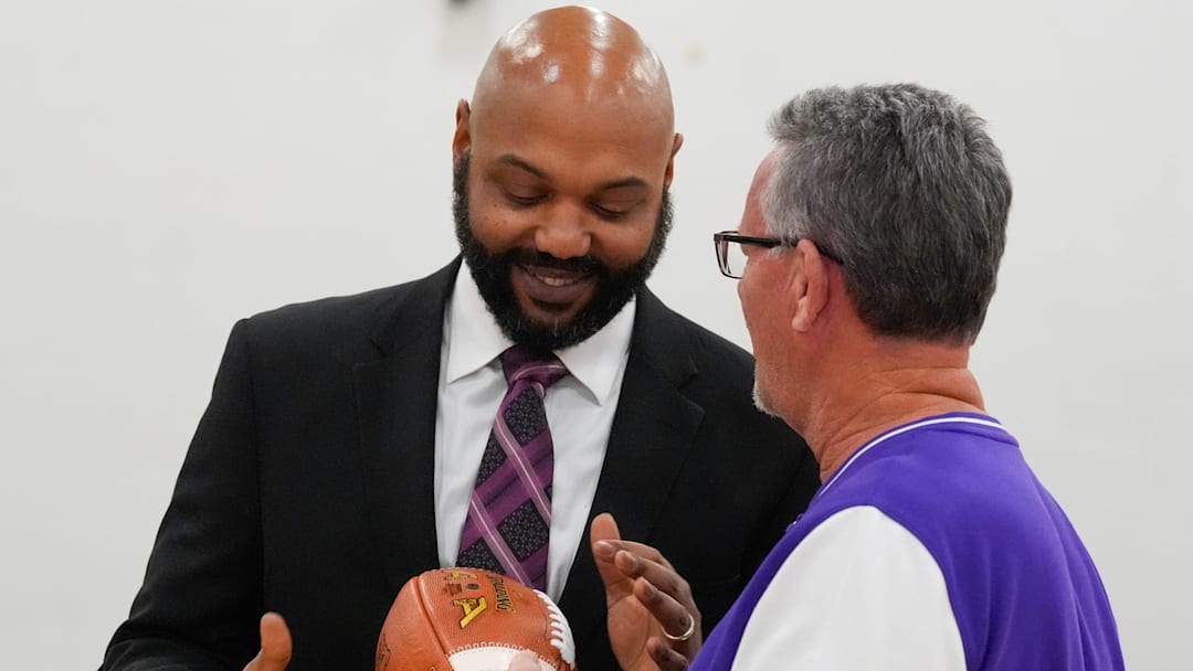Athletic Director John Kelsey hands the football, and Male’s team, to Chase Porter as he was announced as the new coach at Louisville Male High School on Friday, December 19, 2025