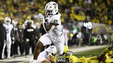 Oct 4, 2024; Eugene, Oregon, USA; Michigan State Spartans running back Kay'Ron Lynch-Adams (15) breaks away from Oregon Ducks defensive back Dakoda Fields (11) during the second half at Autzen Stadium. Mandatory Credit: Troy Wayrynen-Imagn Images