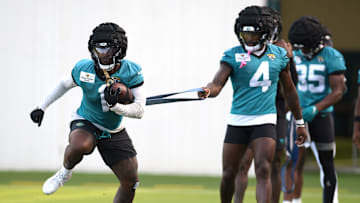Jacksonville Jaguars running back Tank Bigsby (4) holds the elastic band attached to running back Travis Etienne Jr. (1) as they go through drills on the fifth day of the NFL football training camp practice session Monday, July 29, 2024 at EverBank Stadium's Miller Electric Center in Jacksonville, Fla.. [Bob Self/Florida Times-Union]
