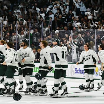 Members of the MSU Spartan hockey team celebrate their 4-3 double overtime win against Ohio State, Saturday, March 22, 2025, to win the Big 10 Hockey Championship at Munn Ice Arena.
