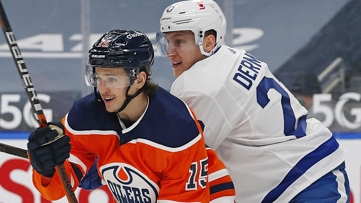 Mar 1, 2021; Edmonton, Alberta, CAN; Edmonton Oilers forward Josh Archibald (15) and Toronto Maple Leafs defensemen Travis Dermott (23) battle for position during the first period at Rogers Place. Mandatory Credit: Perry Nelson-Imagn Images