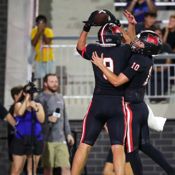 Receiver Jacob Nye of Melissa and teammate Noah Schuback celebrate a touchdown. 