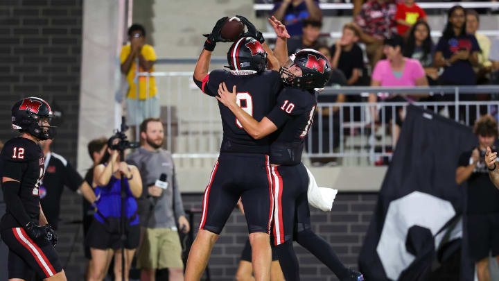 Receiver Jacob Nye of Melissa and teammate Noah Schuback celebrate a touchdown. 