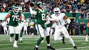 Jan 5, 2025; East Rutherford, New Jersey, USA; New York Jets quarterback Aaron Rodgers (8) throws a touchdown pass to New York Jets wide receiver Davante Adams (17) (not pictured) during the fourth quarter of their game against the Miami Dolphins at MetLife Stadium. Mandatory Credit: Ed Mulholland-Imagn Images