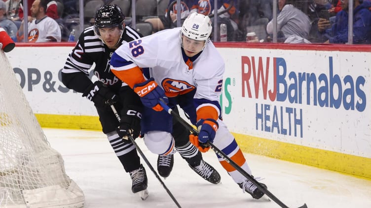 Apr 15, 2024; Newark, New Jersey, USA; New York Islanders defenseman Alexander Romanov (28) and New Jersey Devils left wing Tomas Nosek (92) battle for the puck during the second period at Prudential Center. Mandatory Credit: Ed Mulholland-USA TODAY Sports