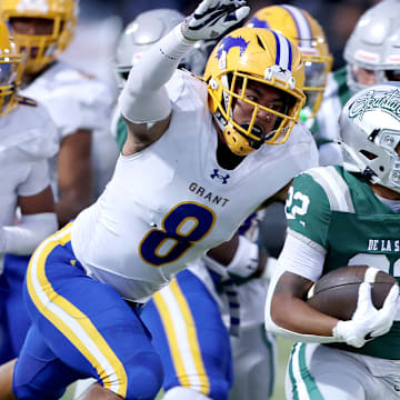 Running back Derrick Blanche (right) of De La Salle attempts to elude Grant linebacker Jeremiah Tuiileila. Grant has another tough tussle, traveling to Central Section power Clovis East. 