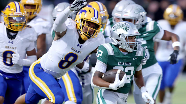 Running back Derrick Blanche (right) of De La Salle attempts to elude Grant linebacker Jeremiah Tuiileila. Grant has another tough tussle, traveling to Central Section power Clovis East. 