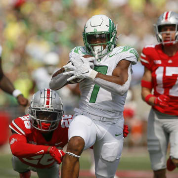 Oregon running back CJ Verdell runs past Ohio State  safety Bryson Shaw (17) and cornerback Cameron Brown (26) for a 77-yard touchdown on Saturday. Verdell scored two touchdowns.