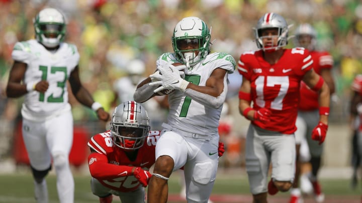 Oregon running back CJ Verdell runs past Ohio State  safety Bryson Shaw (17) and cornerback Cameron Brown (26) for a 77-yard touchdown on Saturday. Verdell scored two touchdowns.