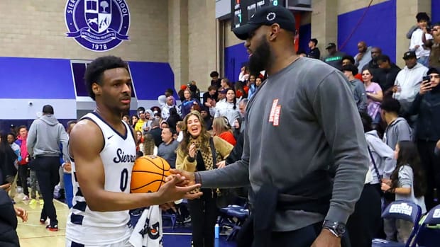 Bronny James receives congratulations from his father, LeBron, following a home playoff game during his senior season.