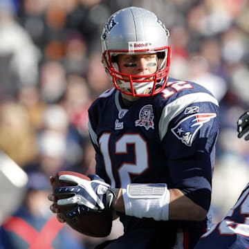 New England Patriots quarterback Tom Brady tries to evade Baltimore Ravens linebacker Ray Lewis.