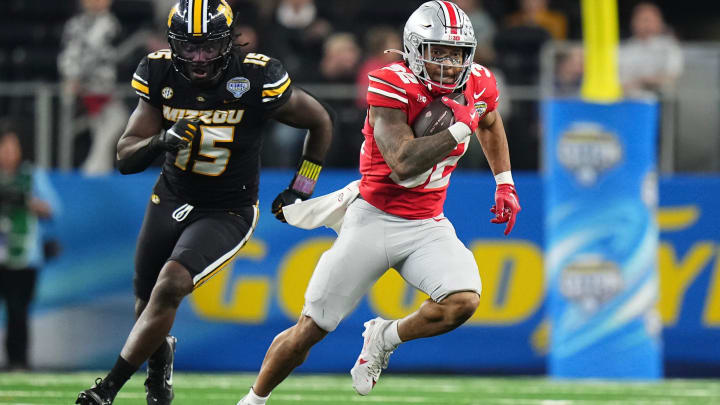 Dec 29, 2023; Arlington, Texas, USA; Ohio State Buckeyes running back TreVeyon Henderson (32) runs away from Missouri Tigers defensive lineman Johnny Walker Jr. (15) during the third quarter of the Goodyear Cotton Bowl Classic at AT&T Stadium. Ohio State lost 14-3.