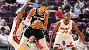 Oct 8, 2025; Miami, Florida, USA;  San Antonio Spurs center Victor Wembanyama (1) looks for room as Miami Heat center Bam Adebayo (13) and forward Andrew Wiggins (22) defend during the first half at Kaseya Center. Mandatory Credit: Jim Rassol-Imagn Images
