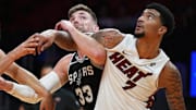Oct 8, 2025; Miami, Florida, USA;  San Antonio Spurs center Micah Potter (33) battles for a rebound with Miami Heat center Kel'El Ware (7) during the second half at Kaseya Center. Mandatory Credit: Jim Rassol-Imagn Images