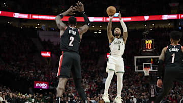 Jan 31, 2024; Portland, Oregon, USA; Milwaukee Bucks guard Damian Lillard (0) shoots a jump shot during the first half against Portland Trail Blazers center Deandre Ayton (2) at Moda Center. Mandatory Credit: Troy Wayrynen-Imagn Images